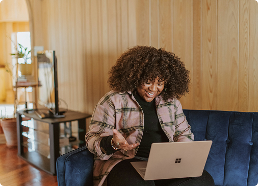 Woman working on laptop on sofa